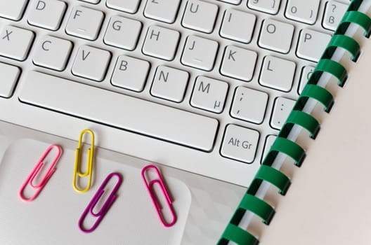 Bright keyboard,spiral notebook,colorful paper clips