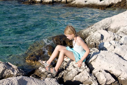 little girl sitting on the rocks