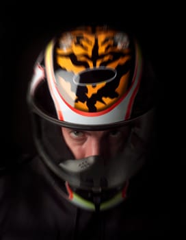 Man with motorcycle helmet on black background