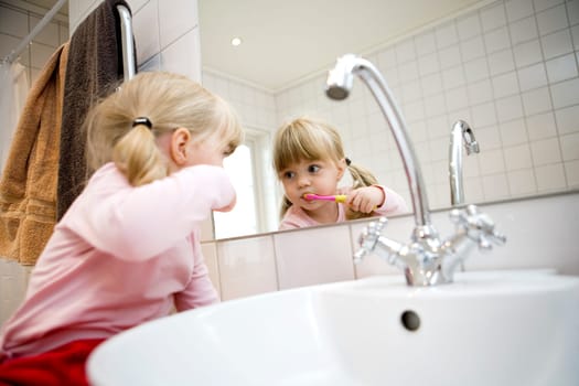 Baby Girl with toothbrush in the bathroom