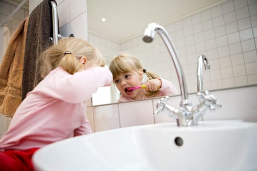 Baby Girl with toothbrush in the bathroom