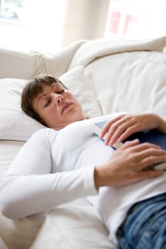 Sleeping woman in the sofa with a book