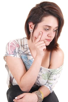 A pretty teenage girl with one hand at her chicks, looking aside and  day dreaming, for white background.