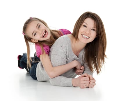 Pretty young mother and daughter cuddling playfully on white background.