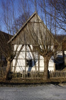 Half-timbered house with fence and willow