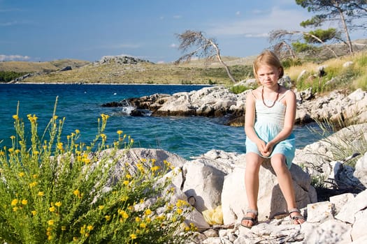 little girl sitting on the rocks