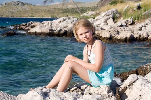 little girl sitting on the rocks