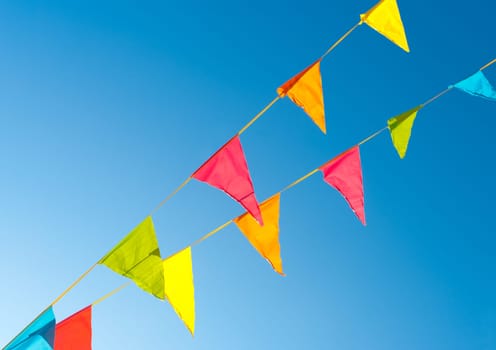 colorful bunting flags against a blue saturated sky