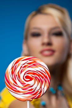 big striped spiral lollipop and blond woman at background