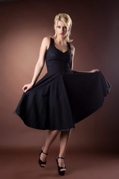 Cute woman in black pinup style dance on dark background