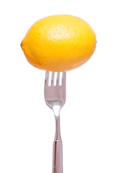 A yellow lemon on a fork against an isolated background