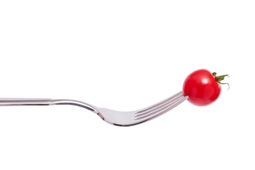 A small red cocktail tomato is skewered on a fork