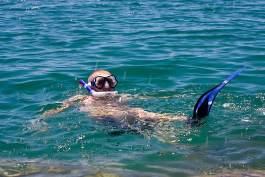 man in the water with fins mask and snorkel