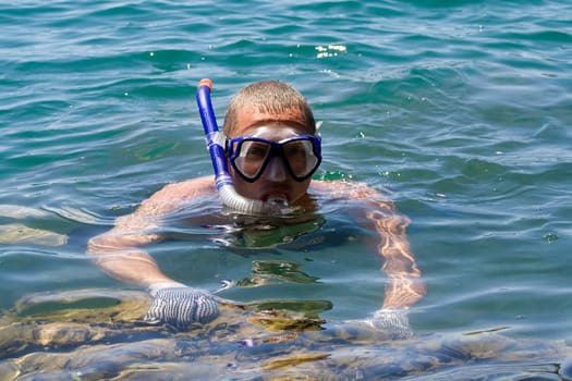 man in the water with fins mask and snorkel
