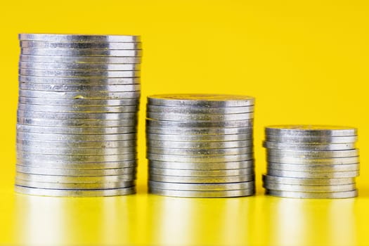 stacks of silver coins on yellow background