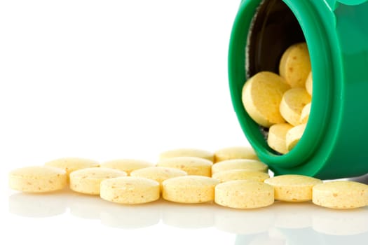 pill bottle with yellow pills on white background
