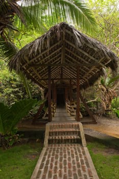 Wooden bridge with roof of straw on a river in Ecuador