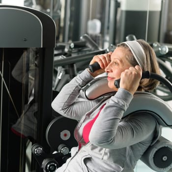 Fitness center senior woman exercise abs muscle on gym machine