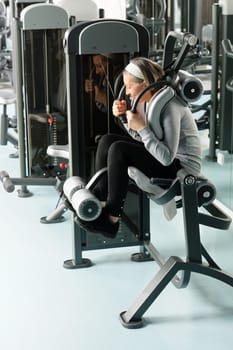 Fitness center senior woman exercise abs muscle on gym machine