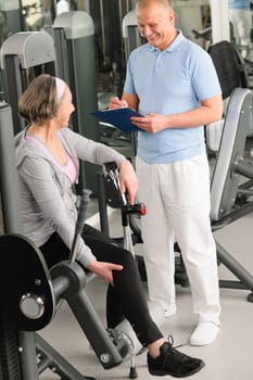 Physical therapist male assist active senior woman exercise at gym