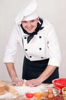 cook kneads the dough for cooking