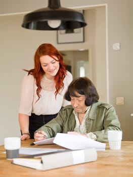 Young woman helping her Grandmother with paperwork