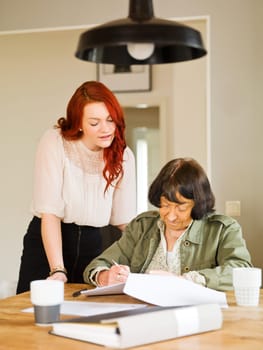 Young woman helping her Grandmother with paperwork