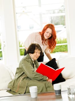 Young woman and her Grandmother looking in the Photo Album