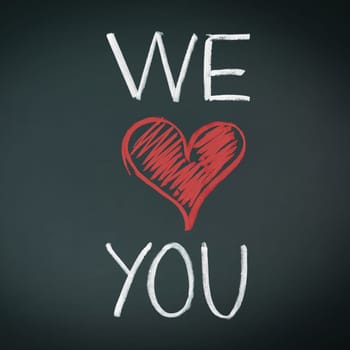 We Love You. Handwriiten message in chalk on a blackboard incorporating a red heart symbol for love.