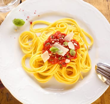 Plate of freshly prepared spaghetti bolognaise with a tomato sauce and cheese ready to be served.