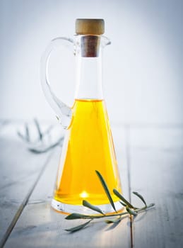 Olive Oil Carafe with herbs and a vignette, standing on a wooden white plate, for italian kitchen.