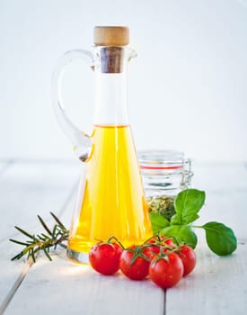 Ingredients for Tagliatelle, olive oil, tomatoes, fresh basil and herbs for seasoning, standing on painted white boards.