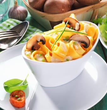 Closeup of a white boat-shaped dish of tasty tagliatelle with mushrooms