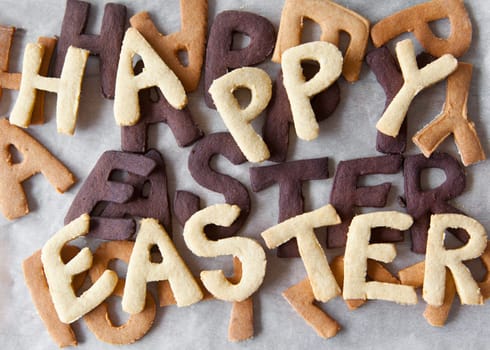 Easter Biscuit background of scrumptious freshly baked alphabet biscuits spelling the words Happy Easter