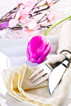Spring Table setting with a tulip and a cherry blossom in the background