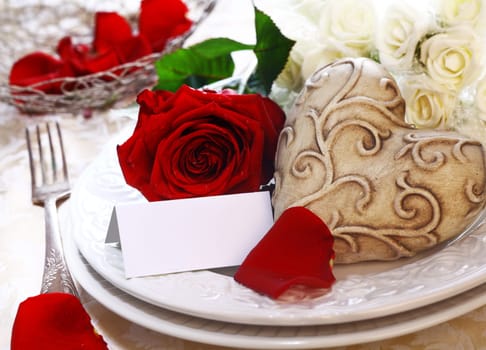Wedding Place Setting with a place card, red and white roses and a heart