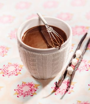 White ceramic cup of delicious thick whisked melted chocolate with vanilla pods and sugar