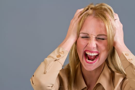 frustrated and screaming woman over a grey background