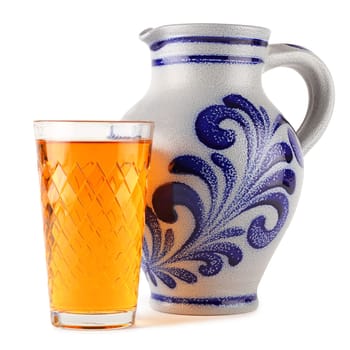 Cider glass in front of a cider pitcher.