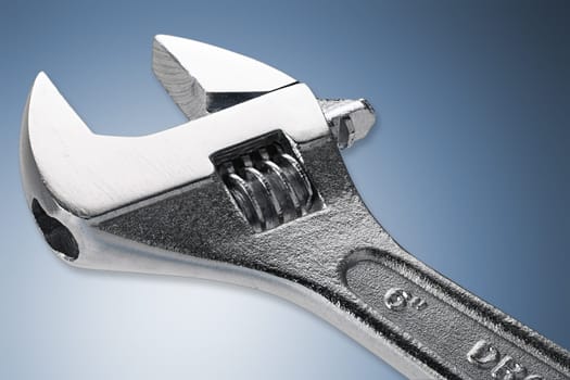 adjustable open-end wrench against blue background
