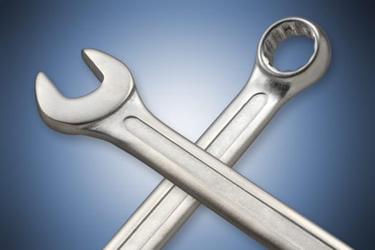Mouth and ring wrench against blue background