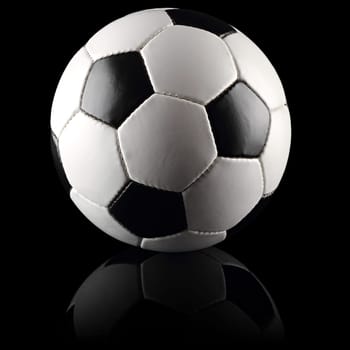 Black and white soccer ball on black background.