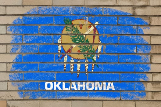Chalky and grunge american state of oklahoma flag painted with color chalk on brick wall