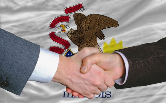 two businessmen shaking hands after good business investment  agreement in america, in front US state flag of illinois