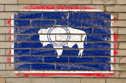 Chalky american state of wyoming flag painted with color chalk on brick wall