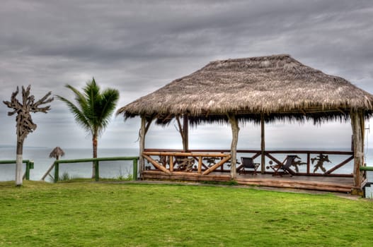 wooden hut with a roof of palm leaves on a beach in Ecuador
