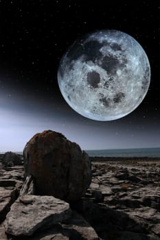 boulders in rocky landscape of the burren in county clare ireland with bright moon in night sky