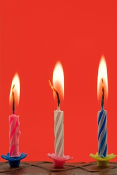 birthday candles in a cake, on red background