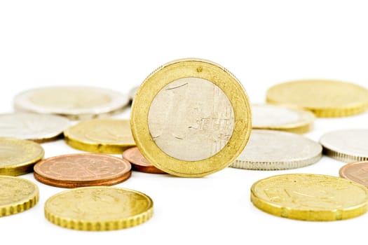 one euro coin in a middle of other coins