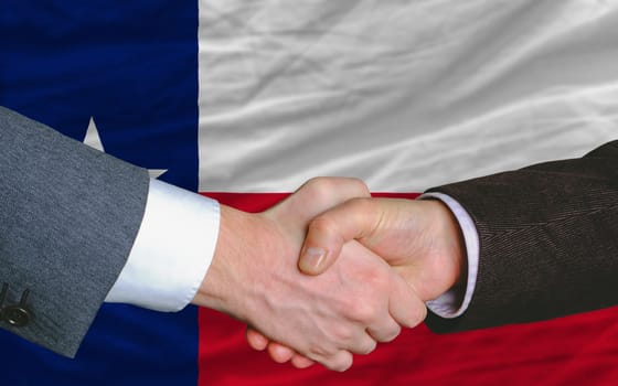 two businessmen shaking hands after good business investment agreement in front US state flag of texas